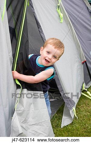 2 year old boy peeping round the doorway of a tent. View Large Photo Image Picture - 2 year old boy peeping round the doorway of a tent.. Fotosearch
