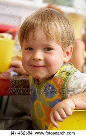2 year old boy sitting at nursery, grinning into camera. View Large Photo Image Picture - 2 year old boy sitting at nursery, grinning into camera.. Fotosearch