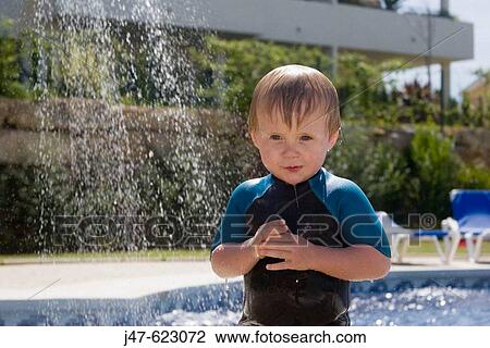 2 year old boy standing under a shower outside, wearing a wetsuit View Large Photo Image Stock Image - 2 year old boy standing under a shower outside, wearing a wetsuit. Fotosearch