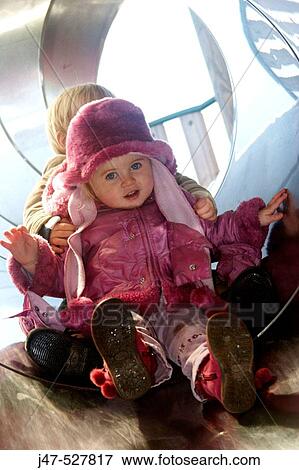 2 year old girl and boy r in the playground sliding down a tunnel slide, smiling into camera View Large Photo Image Stock Photo - 2 year old girl and boy r in the playground sliding down a tunnel slide, smiling into camera. Fotosearch