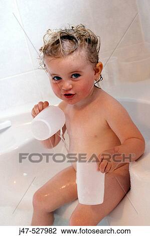 Stock Image - 2 year old girl in the bath, smiling into camera. Fotosearch