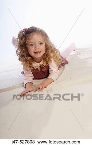 2 year old girl lying on the floor in the studio smiling into camera View Large Photo Image Stock Photo - 2 year old girl lying on the floor in the studio smiling into camera. Fotosearch