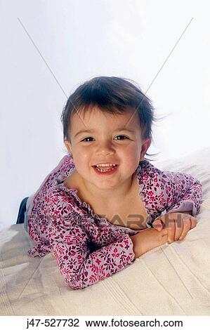 2 year old girl lying on tummy, smiling into camera View Large Photo Image Stock Image - 2 year old girl lying on tummy, smiling into camera. Fotosearch