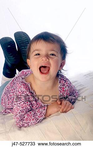 2 year old girl lying on tummy, laughing into camera View Large Photo Image Stock Image - 2 year old girl lying on tummy, laughing into camera. Fotosearch