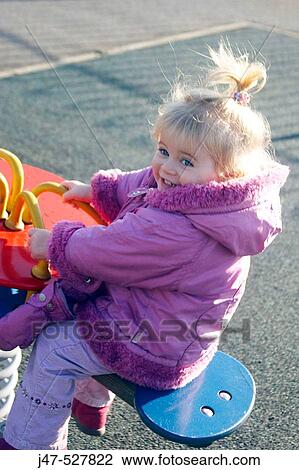 2 year old girl on a rocker in the playground smiling in delight View Large Photo Image Stock Image - 2 year old girl on a rocker in the playground smiling in delight. Fotosearch