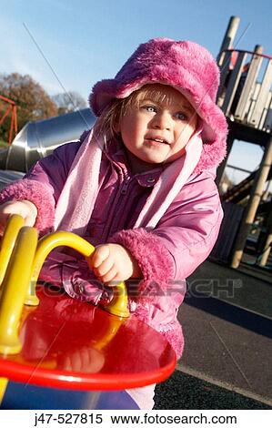 2 year old girl on a rocker in the playground smiling in delight, wearing a big pink hat and scarf View Large Photo Image Stock Photography - 2 year old girl on a rocker in the playground smiling in delight, wearing a big pink hat and scarf. Fotosearch