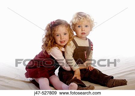 2 year old girl sitting with her little brother, in the studio, smiling into camera View Large Photo Image Stock Photo - 2 year old girl sitting with her little brother, in the studio, smiling into camera. Fotosearch