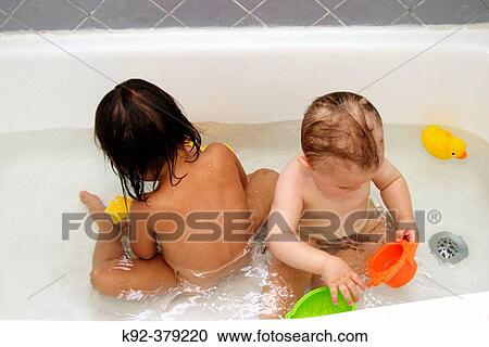 Stock Image - 2-year-old Vietnamese girl and 1-year-old American boy in a bathtub. Fotosearch