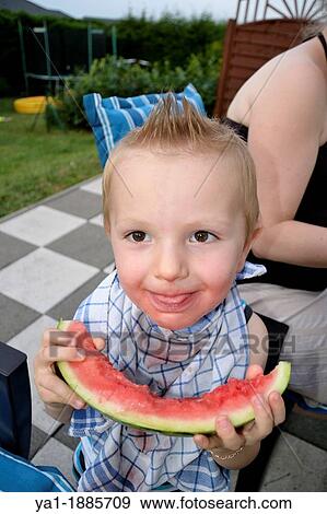 2 years boy eating by himself a watermelon slice, France View Large Photo Image Stock Photo - 2 years boy eating by himself a watermelon slice, France. Fotosearch