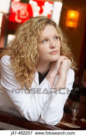 Stock Photo - 20 year old girl in a bar looking off camera. Fotosearch