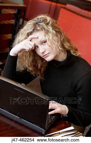 20 year old girl in a bar working on a laptop, looking fedup View Large Photo Image Picture - 20 year old girl in a bar working on a laptop, looking fedup. Fotosearch