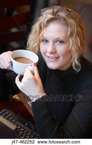 20 year old girl sitting in a bar with a cup of coffee smiling into camera View Large Photo Image Stock Image - 20 year old girl sitting in a bar with a cup of coffee smiling into camera. Fotosearch