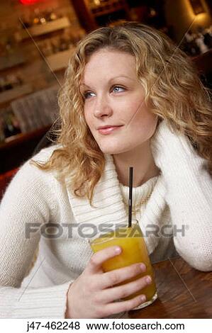 20 year old girl sitting in a bar with a glass of orange View Large Photo Image Stock Photo - 20 year old girl sitting in a bar with a glass of orange. Fotosearch