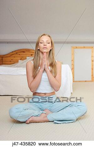 20 Year Old Girl Sitting In Bedroom Practicing Yoga