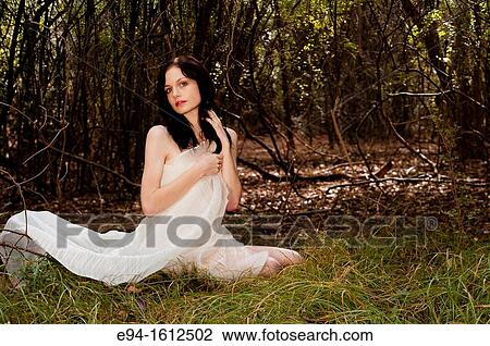 20 year old woman wrapped in white fabric sitting on the ground in a forest setting View Large Photo Image Stock Image - 20 year old woman wrapped in white fabric sitting on the ground in a forest setting. Fotosearch