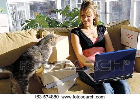 20 yr old woman home shopping on laptop computer looking at pet cat View Large Photo Image Stock Image - 20 yr old woman home shopping on laptop computer looking at pet cat. Fotosearch