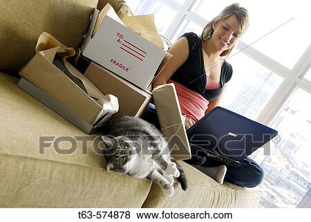20 yr old woman home shopping on laptop computer looking at pet cat View Large Photo Image Stock Photo - 20 yr old woman home shopping on laptop computer looking at pet cat. Fotosearch