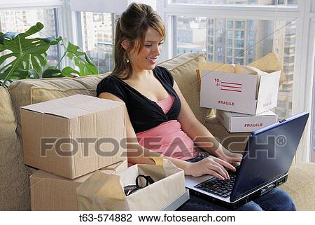 20 yr old woman home shopping with laptop computer with parcels around her on sofa View Large Photo Image Stock Image - 20 yr old woman home shopping with laptop computer with parcels around her on sofa. Fotosearch