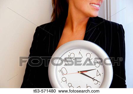 20 yr old young woman holding clock in office View Large Photo Image Stock Image - 20 yr old young woman holding clock in office. Fotosearch