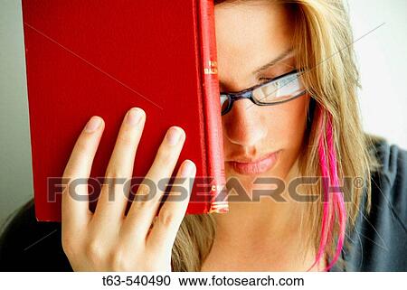 20 yr old young woman holding red book on forehead View Large Photo Image Stock Image - 20 yr old young woman holding red book on forehead. Fotosearch
