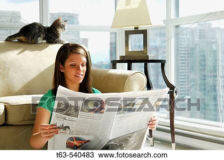 20 yr old young woman sitting in apartment reading newspaper View Large Photo Image Stock Image - 20 yr old young woman sitting in apartment reading newspaper. Fotosearch