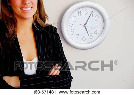 20 yr old young woman smiling standing next to clock on wall View Large Photo Image Stock Image - 20 yr old young woman smiling standing next to clock on wall. Fotosearch