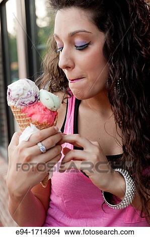 21 year old brunette woman eating an ice cream cone View Large Photo Image Picture - 21 year old brunette woman eating an ice cream cone. Fotosearch