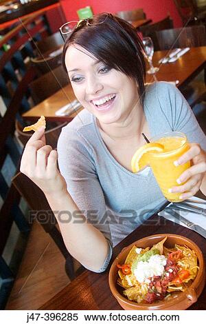 21 year old girl in restaurant eating nachos, laughing View Large Photo Image Stock Photography - 21 year old girl in restaurant eating nachos, laughing. Fotosearch