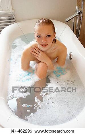 Stock Photography - 21 year old girl in the bath, smiling. Fotosearch