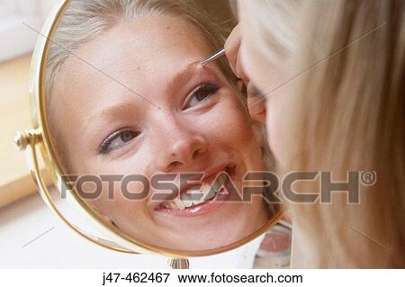 21 year old girl looking in the mirror plucking her eyebrows View Large Photo Image Stock Photo - 21 year old girl looking in the mirror plucking her eyebrows. Fotosearch