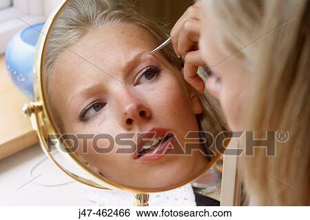 21 year old girl looking in the mirror plucking her eyebrows View Large Photo Image Stock Photograph - 21 year old girl looking in the mirror plucking her eyebrows. Fotosearch