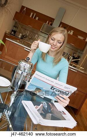 21 year old girl sitting at the kitchen table reading the paper, drinking coffee View Large Photo Image Stock Image - 21 year old girl sitting at the kitchen table reading the paper, drinking coffee. Fotosearch