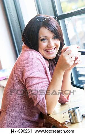 21 year old girl, sitting in bar, smiling at camera, holding a cup of coffee View Large Photo Image Stock Image - 21 year old girl, sitting in bar, smiling at camera, holding a cup of coffee. Fotosearch