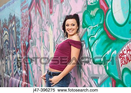 21 year old girl, standing against a wall graffitti, smiling off camera View Large Photo Image Stock Photography - 21 year old girl, standing against a wall graffitti, smiling off camera. Fotosearch
