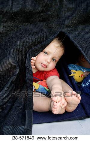 Stock Photo - 22 month old twin boy looking out of pram, twin brother next to him, UK. Fotosearch