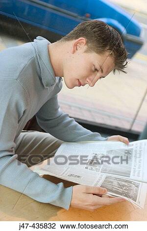 22 year old boy sitting with the newspaper, reading View Large Photo Image Stock Image - 22 year old boy sitting with the newspaper, reading. Fotosearch