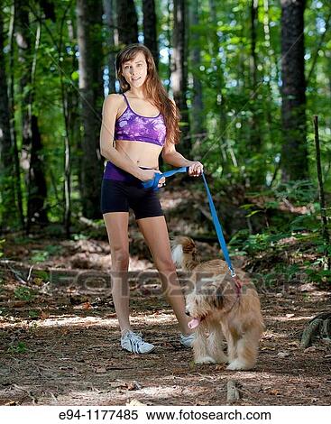 23 year old brunette woman dressed in exercise clothing walking her dog through a forest View Large Photo Image Stock Photography - 23 year old brunette woman dressed in exercise clothing walking her dog through a forest. Fotosearch