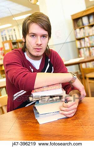 24 year old man leaning over a book, serious expression, in the library View Large Photo Image Stock Photo - 24 year old man leaning over a book, serious expression, in the library. Fotosearch