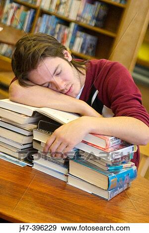 24 year old man leaning over a pile of books, asleep, in the library View Large Photo Image Stock Photo - 24 year old man leaning over a pile of books, asleep, in the library. Fotosearch