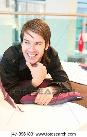 24 year old man lying on bed, smiling, looking away from camera, hand up to mouth View Large Photo Image Stock Image - 24 year old man lying on bed, smiling, looking away from camera, hand up to mouth. Fotosearch