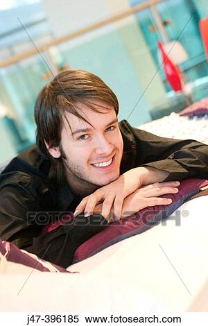 24 year old man lying on bed, smiling, looking into camera View Large Photo Image Stock Photography - 24 year old man lying on bed, smiling, looking into camera. Fotosearch