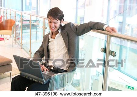 24 year old man sitting in chair, smiling expression, working on laptop View Large Photo Image Stock Photo - 24 year old man sitting in chair, smiling expression, working on laptop. Fotosearch