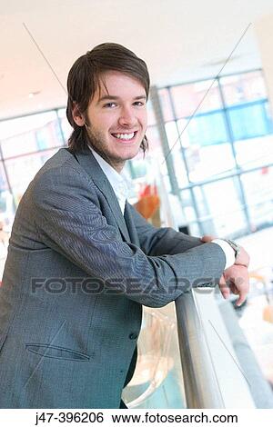 24 year old man standing against barrier smiling into camera View Large Photo Image Stock Photograph - 24 year old man standing against barrier smiling into camera. Fotosearch