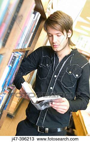 24 year old man standing, reading books, serious expression, in the library View Large Photo Image Stock Image - 24 year old man standing, reading books, serious expression, in the library. Fotosearch