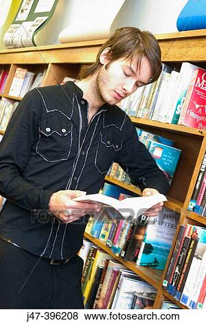 24 year old man standing, reading books, serious expression, in the library View Large Photo Image Stock Photo - 24 year old man standing, reading books, serious expression, in the library. Fotosearch