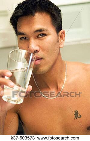25-30 y/o Asian man in kitchen drinking water. View Large Photo Image Stock Image - 25-30 y/o Asian man in kitchen drinking water.. Fotosearch