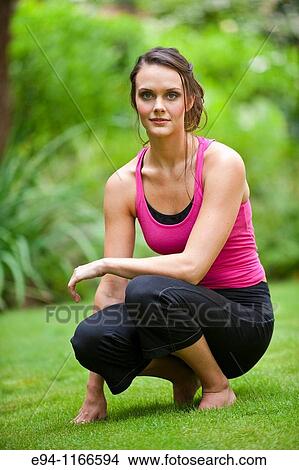 25 year old brunette woman in a garden settng wearing work out clothing looking at camera View Large Photo Image Picture - 25 year old brunette woman in a garden settng wearing work out clothing looking at camera. Fotosearch