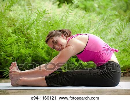 25 year old brunette woman in a garden settng wearing work out clothing, stretching and exercising looking at the camera. View Large Photo Image Stock Image - 25 year old brunette woman in a garden settng wearing work out clothing, stretching and exercising looking at the camera.. Fotosearch