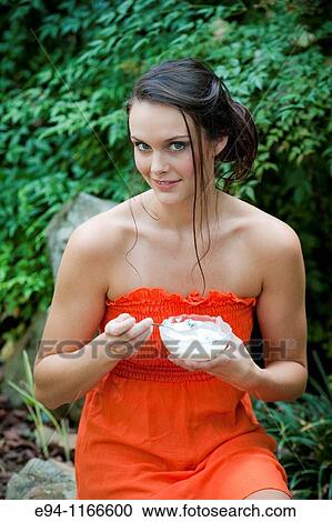 25 year old brunette woman in a garden settng wearing a dress looking at the camera and holding a bowl of yogurt View Large Photo Image Stock Image - 25 year old brunette woman in a garden settng wearing a dress looking at the camera and holding a bowl of yogurt. Fotosearch