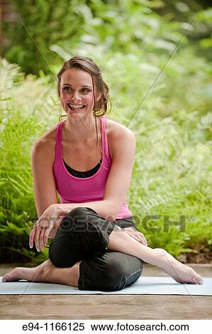 25 year old brunette woman in a garden settng wearing work out clothing, sitting on the ground smiling at the camera. View Large Photo Image Stock Photography - 25 year old brunette woman in a garden settng wearing work out clothing, sitting on the ground smiling at the camera.. Fotosearch